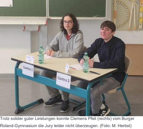 Zusehen sind zwei Teilnehmer vom Wettbewerb "Jugend debattiert". Rechts zusehen ist Clemens Pfeil vom Burger Roland-Gymnasium